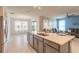 Bright open-concept kitchen with an island and barstool seating, and a living area with ample sunlight at 2840 Monaghan Dr, Ormond Beach, FL 32174