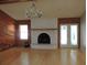 Cozy living room features a brick fireplace, hardwood floors, and double doors leading to the outside at 543 Sandy Oaks Blvd, Ormond Beach, FL 32174