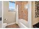 Bathroom with shower over tub, white fixtures, and light tile flooring at 568 Luna Bella Ln, New Smyrna Beach, FL 32168