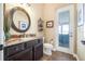 Bathroom featuring custom vanity, granite countertop, decorative mirror and lighting at 568 Luna Bella Ln, New Smyrna Beach, FL 32168
