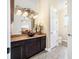 Bathroom featuring dark wood cabinets, decorative lighting, vessel sink and granite countertops at 568 Luna Bella Ln, New Smyrna Beach, FL 32168