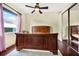 Bedroom features a dark wood bedframe, ceiling fan, and natural light from a window at 568 Luna Bella Ln, New Smyrna Beach, FL 32168