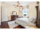 Cozy bedroom with wood floors, ceiling fan, dresser, and white comforter at 568 Luna Bella Ln, New Smyrna Beach, FL 32168