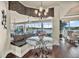 Charming breakfast nook features a glass table, banquette seating, and views of the backyard and waterfront at 568 Luna Bella Ln, New Smyrna Beach, FL 32168