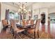 Elegant dining room featuring coffered ceilings, crystal chandelier, and large windows overlooking the outdoors at 568 Luna Bella Ln, New Smyrna Beach, FL 32168