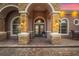 Gorgeous home entrance with a custom stone archway, elegant front door and outdoor sconces at 568 Luna Bella Ln, New Smyrna Beach, FL 32168