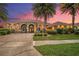 Beautiful single-story home boasting a brick driveway, lush landscaping, and mature palm trees at sunset at 568 Luna Bella Ln, New Smyrna Beach, FL 32168