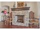 Living room with a stone fireplace, hardwood floors, decorative chairs, and ample light at 568 Luna Bella Ln, New Smyrna Beach, FL 32168