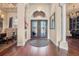 Elegant foyer with hardwood floors, chandelier, and ornate double doors leading to dining room at 568 Luna Bella Ln, New Smyrna Beach, FL 32168