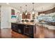 Kitchen island with pendant lighting, granite countertops, seating, and view to breakfast nook at 568 Luna Bella Ln, New Smyrna Beach, FL 32168