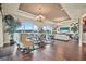 Spacious living room with hardwood floors, large windows overlooking the lake, and stylish furniture at 568 Luna Bella Ln, New Smyrna Beach, FL 32168