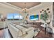 Comfortable living room featuring a white sofa, large television, hardwood floors, and water views at 568 Luna Bella Ln, New Smyrna Beach, FL 32168