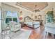 Luxurious main bedroom featuring hardwood floors, elegant decor, and a comfortable seating area at 568 Luna Bella Ln, New Smyrna Beach, FL 32168