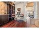 A stylish wine cellar with custom racks and mosaic tiles, complemented by a wrought iron table set for two at 568 Luna Bella Ln, New Smyrna Beach, FL 32168