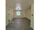 Bright living room with new gray wood floors, a window, and a front door at 741 Ellen St, Daytona Beach, FL 32114