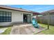 Backyard patio with a blue outdoor chair and bench, overlooking the grassy yard at 915 Stonybrook Cir, Port Orange, FL 32127