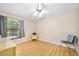 Bright bedroom with wood floors, ceiling fan, and a large window at 915 Stonybrook Cir, Port Orange, FL 32127