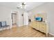 Bedroom with wooden floors, ceiling fan, and decorative dresser with mirror at 915 Stonybrook Cir, Port Orange, FL 32127