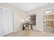 Cozy bedroom featuring a window, desk, closet, and neutral carpet, adjacent to kitchen at 915 Stonybrook Cir, Port Orange, FL 32127
