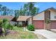 Charming exterior view showcasing home with garage, brick accents, and manicured landscaping at 915 Stonybrook Cir, Port Orange, FL 32127