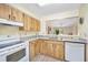 Bright kitchen featuring updated countertops, white appliances, and a pass-through window to the dining area at 915 Stonybrook Cir, Port Orange, FL 32127