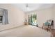 Bright living room with sliding glass door, carpet, and cozy accent chair at 915 Stonybrook Cir, Port Orange, FL 32127