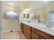 Bright bathroom features wood cabinets, double sinks, walk-in shower and tile flooring at 3345 Tesoro Cir, New Smyrna Beach, FL 32168