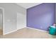 Bright bedroom with white closet doors, tile floors, and purple accent wall at 3345 Tesoro Cir, New Smyrna Beach, FL 32168