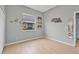 Well-lit bedroom featuring a window, wood-look tile flooring and neutral walls at 3345 Tesoro Cir, New Smyrna Beach, FL 32168