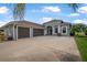 Charming home featuring a three-car garage, a well manicured lawn and lovely tropical landscaping at 3345 Tesoro Cir, New Smyrna Beach, FL 32168