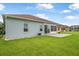 Side view of blue home featuring green lawn, brick paved patio and enclosed lanai at 3345 Tesoro Cir, New Smyrna Beach, FL 32168
