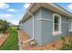 Blue home exterior with white trim, rock garden and manicured lawn at 3345 Tesoro Cir, New Smyrna Beach, FL 32168