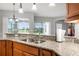 Beautiful kitchen featuring granite countertops, stainless steel sink, and views to the outside at 3345 Tesoro Cir, New Smyrna Beach, FL 32168