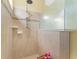 The shower features tiled walls, a shower head, glass wall, and a small wooden bench at 3345 Tesoro Cir, New Smyrna Beach, FL 32168