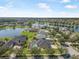 Panoramic aerial perspective of houses with screened pools and manicured yards nestled along a scenic lake with fountain at 3615 Marisol Ct, New Smyrna Beach, FL 32168