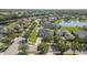 A picturesque aerial view showcasing a community of homes encircling a serene lake with a fountain, lush trees, and manicured lawns at 3615 Marisol Ct, New Smyrna Beach, FL 32168