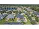 Scenic aerial view of a neighborhood with well-kept houses, swimming pools, and green spaces situated around a tranquil lake at 3615 Marisol Ct, New Smyrna Beach, FL 32168