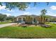 Inviting home exterior featuring a manicured lawn, front garden, palm trees, and comfortable seating area at 3615 Marisol Ct, New Smyrna Beach, FL 32168
