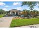 Charming single-story home with arched entryway, manicured lawn, palm trees and a welcoming front garden at 3615 Marisol Ct, New Smyrna Beach, FL 32168