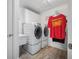 Functional laundry room with modern washer and dryer units, ample storage, and vinyl flooring at 3615 Marisol Ct, New Smyrna Beach, FL 32168