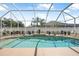 A private screened-in pool is surrounded by tasteful decor and a white privacy fence at 3615 Marisol Ct, New Smyrna Beach, FL 32168