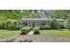 Charming single-story home with a welcoming front porch, beautiful landscaping, and an American flag at 3720 Willow Ave, Deland, FL 32720