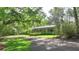 Single-story home with a charming front porch and beautiful landscaping, nestled among mature trees at 3720 Willow Ave, Deland, FL 32720