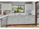 Classic white kitchen with ample counter space, stainless steel dishwasher, and natural light from a large window at 3720 Willow Ave, Deland, FL 32720