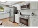 Well-equipped kitchen with stainless steel appliances, white subway tile backsplash, and wood floors at 3720 Willow Ave, Deland, FL 32720