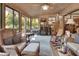 Inviting sunroom with brick accent wall and wicker furniture, perfect for relaxing and enjoying the natural light at 3720 Willow Ave, Deland, FL 32720