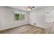 Bedroom featuring wood-look flooring, ceiling fan and large window at 4901 Sailfish Dr, Ponce Inlet, FL 32127