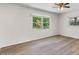 Bedroom featuring wood-look flooring, ceiling fan and two windows at 4901 Sailfish Dr, Ponce Inlet, FL 32127