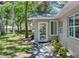 A welcoming entrance with a glass door and a lush green lawn with mature trees at 4901 Sailfish Dr, Ponce Inlet, FL 32127
