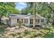 Charming single-story home featuring mature trees, lush green lawn and a cozy enclosed porch at 4901 Sailfish Dr, Ponce Inlet, FL 32127